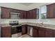 Modern kitchen features stainless steel appliances, granite countertops, and dark wood cabinetry at 34847 Daisy Meadow Loop, Zephyrhills, FL 33541