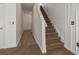 Hallway with carpeting and luxury vinyl plank flooring near a staircase, with neutral colored walls at 34855 Daisy Meadow Loop, Zephyrhills, FL 33541