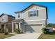 Two story home with a muted color scheme, attached garage, and manicured lawn at 34855 Daisy Meadow Loop, Zephyrhills, FL 33541