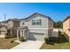 Two story home featuring an attached garage, muted color scheme, and manicured lawn at 34855 Daisy Meadow Loop, Zephyrhills, FL 33541