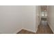 Hallway features laminate flooring leading to a room with carpet and windows, providing ample natural light at 34855 Daisy Meadow Loop, Zephyrhills, FL 33541