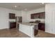 The open kitchen features stainless steel appliances, granite countertops and large kitchen island at 34855 Daisy Meadow Loop, Zephyrhills, FL 33541