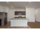 The open kitchen features stainless steel appliances, granite countertops and large kitchen island at 34855 Daisy Meadow Loop, Zephyrhills, FL 33541