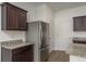 This modern kitchen is equipped with stainless steel refrigerator and granite countertops at 34855 Daisy Meadow Loop, Zephyrhills, FL 33541