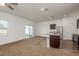 Open-concept living room and kitchen with natural light, kitchen island, stainless appliances, and sliding glass doors at 34855 Daisy Meadow Loop, Zephyrhills, FL 33541