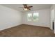 The main bedroom features neutral walls, plush carpeting, and windows with beautiful views at 34855 Daisy Meadow Loop, Zephyrhills, FL 33541