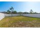 Large backyard with green grass, white fence, and trees at 34866 Daisy Meadow Loop, Zephyrhills, FL 33541
