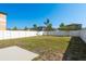 Large backyard with green grass, white fence, and trees at 34866 Daisy Meadow Loop, Zephyrhills, FL 33541