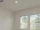 Bright bedroom showcasing two windows with blinds, neutral walls, and ample natural light at 34866 Daisy Meadow Loop, Zephyrhills, FL 33541