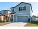 Inviting two-story home boasting blue siding, a tidy lawn, and convenient attached garage at 34866 Daisy Meadow Loop, Zephyrhills, FL 33541