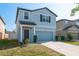 Charming two-story home featuring a well-maintained lawn, inviting front porch, and a two-car garage at 34866 Daisy Meadow Loop, Zephyrhills, FL 33541
