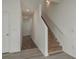 Hallway featuring vinyl flooring, white walls, and access to the staircase, offering a modern look at 34866 Daisy Meadow Loop, Zephyrhills, FL 33541