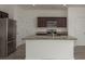 Well-equipped kitchen boasts stainless steel appliances and granite countertops atop dark wood cabinetry at 34866 Daisy Meadow Loop, Zephyrhills, FL 33541