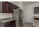Close-up of a kitchen featuring stainless steel refrigerator, granite countertops, and dark wood cabinets at 34866 Daisy Meadow Loop, Zephyrhills, FL 33541