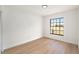 Empty Bedroom featuring wood flooring, white walls, baseboard trim and a large window at 3707 Orangepointe Rd, Valrico, FL 33596