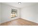 Empty Bedroom featuring wood flooring, white walls, baseboard trim and a large window at 3707 Orangepointe Rd, Valrico, FL 33596