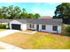 Aerial view of a single-story white home with a black garage door and well-maintained front lawn at 3707 Orangepointe Rd, Valrico, FL 33596