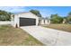 Charming single-story home with a modern white exterior, black trim and garage door, and a well-manicured lawn at 3707 Orangepointe Rd, Valrico, FL 33596