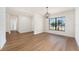 Bright living room featuring hardwood floors, a large window, and modern light fixtures at 3707 Orangepointe Rd, Valrico, FL 33596