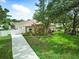 Green front lawn with mature landscaping, driveway, and white privacy fence at 4101 Brooke Dr, Valrico, FL 33594