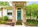 Inviting entrance with brick columns, a teal door, and a well-kept garden at 4101 Brooke Dr, Valrico, FL 33594