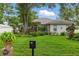 Charming home featuring a lush green lawn, mature trees, and a decorative mailbox at the front of the property at 4101 Brooke Dr, Valrico, FL 33594