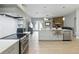 Modern kitchen with gray cabinets, island with seating, and a view to an adjoining living room area with fireplace at 4101 Brooke Dr, Valrico, FL 33594
