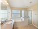 Clean bathroom featuring a corner soaking tub, a glass shower, and neutral decor at 441 Thicket Crest Rd, Seffner, FL 33584