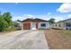 Charming single-story home with a brown roof, white exterior, and driveway at 4935 42Nd N Pl, St Petersburg, FL 33709