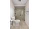 Bathroom featuring a glass-enclosed shower, modern toilet, and tiled floor at 5008 Southshore Dr, New Port Richey, FL 34652