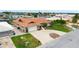 Single-story home with a terracotta roof, well-maintained lawn, and circular driveway at 5008 Southshore Dr, New Port Richey, FL 34652