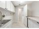 Bright laundry room with tiled floor, storage cabinets, and utility sink at 5008 Southshore Dr, New Port Richey, FL 34652