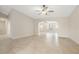 Spacious living room with tile flooring, neutral paint, and an archway that leads to the dining area at 5008 Southshore Dr, New Port Richey, FL 34652