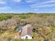 Aerial view showcasing the home, screened-in pool, and surrounding lush landscaping at 6514 Sunhigh Dr, New Port Richey, FL 34655