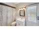 Bright bathroom features a vanity with mirror, toilet, and shower with decorative curtain at 6514 Sunhigh Dr, New Port Richey, FL 34655