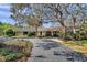 Home exterior featuring a long driveway leading to an attractive home with lush landscaping at 6514 Sunhigh Dr, New Port Richey, FL 34655