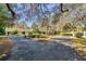 Charming home exterior featuring lush landscaping, mature trees, and a circular driveway at 6514 Sunhigh Dr, New Port Richey, FL 34655