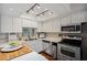 Well-lit kitchen featuring stainless steel appliances, white cabinets, and a sink with a window at 6514 Sunhigh Dr, New Port Richey, FL 34655