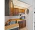 Compact kitchenette featuring stainless steel sink, wooden cabinets, and a microwave at 6514 Sunhigh Dr, New Port Richey, FL 34655