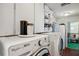 Well-organized laundry room with washer, dryer, storage cabinets and shelving at 6514 Sunhigh Dr, New Port Richey, FL 34655