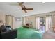 Cozy living room with plenty of natural light, ceiling fan, and access to the yard at 6514 Sunhigh Dr, New Port Richey, FL 34655
