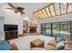 Cozy living room with a stone fireplace, vaulted ceilings, and sliding glass doors to the pool area at 6514 Sunhigh Dr, New Port Richey, FL 34655