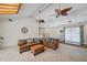 Bright living room featuring a vaulted ceiling with fans, skylight, comfortable seating, and access to the front entryway at 6514 Sunhigh Dr, New Port Richey, FL 34655