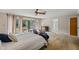 Spacious main bedroom featuring a ceiling fan, ensuite bathroom, and sliding glass doors leading to the pool area at 6514 Sunhigh Dr, New Port Richey, FL 34655