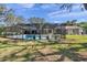 Backyard showcases a large screened-in pool area with seating and greenery at 6514 Sunhigh Dr, New Port Richey, FL 34655
