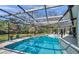 Sparkling blue pool with a screened enclosure, offering a serene and private oasis for swimming and leisure at 6514 Sunhigh Dr, New Port Richey, FL 34655