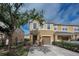 Inviting two-story townhome featuring a tan exterior, attached garage, and a well-maintained front yard with mature tree at 6902 47Th N Ln, Pinellas Park, FL 33781