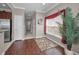 Inviting hallway with rich flooring, leading to the kitchen and featuring a decorative rug and bright window at 6902 47Th N Ln, Pinellas Park, FL 33781