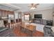 Open-concept living room flows from the kitchen, featuring a ceiling fan, entertainment center with a fireplace and wood flooring at 6902 47Th N Ln, Pinellas Park, FL 33781