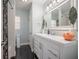 Bright bathroom featuring a modern vanity, stylish mirror, and elegant black and white tiled flooring at 7108 N Howard Ave, Tampa, FL 33604